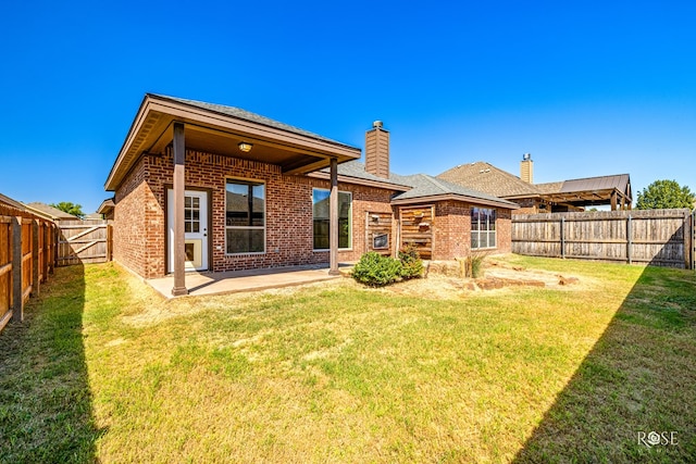 back of house with a lawn and a patio area