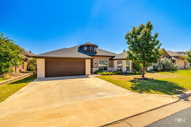 view of front of house featuring a garage and a front lawn