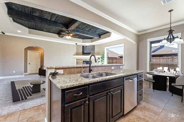 kitchen featuring dark brown cabinetry, sink, crown molding, stainless steel dishwasher, and a kitchen island with sink