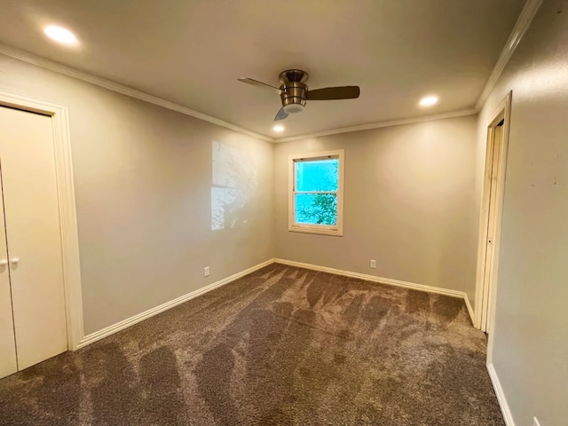 unfurnished room featuring dark colored carpet, ornamental molding, and ceiling fan