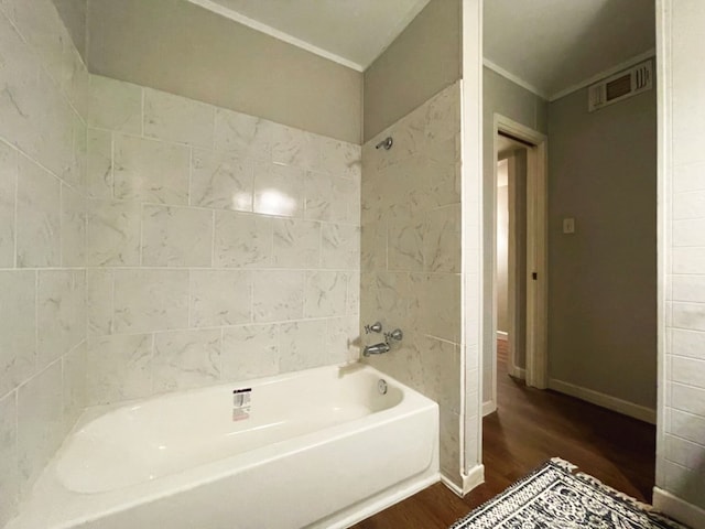 bathroom featuring hardwood / wood-style flooring and washtub / shower combination