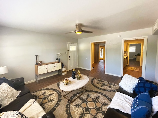 living room featuring ceiling fan and dark hardwood / wood-style flooring