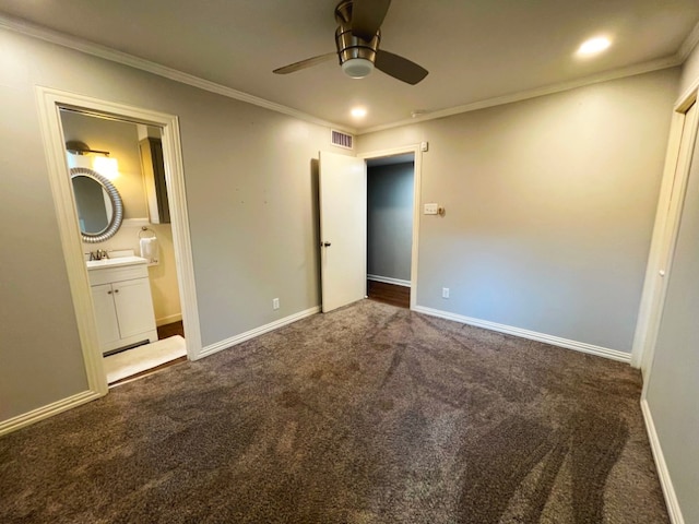 unfurnished bedroom featuring crown molding, ceiling fan, ensuite bath, and dark colored carpet