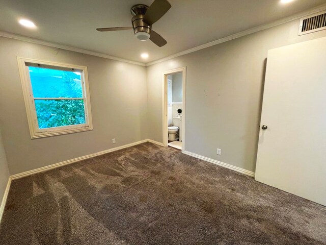 unfurnished bedroom featuring dark carpet, ornamental molding, ceiling fan, and ensuite bathroom