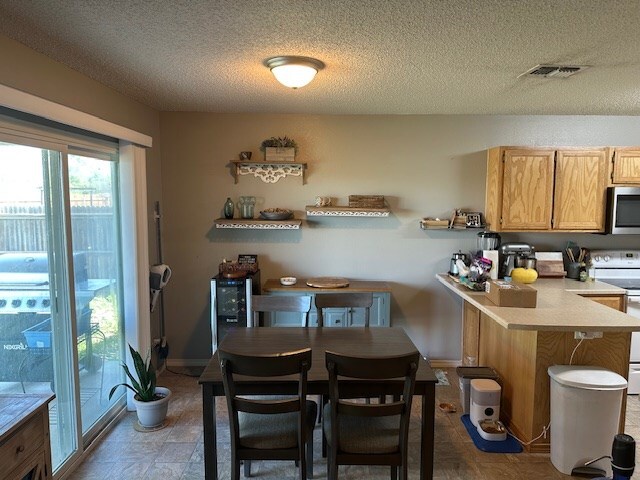 1227 Elmo Ln, San Angelo, TX 76905 - dining room with a textured ceiling and baseboards