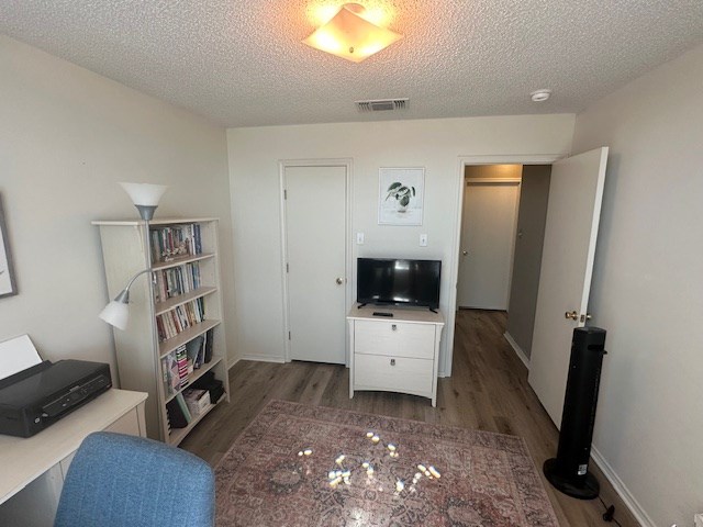 1227 Elmo Ln, San Angelo, TX 76905 - living room featuring a textured ceiling and wood finished floors