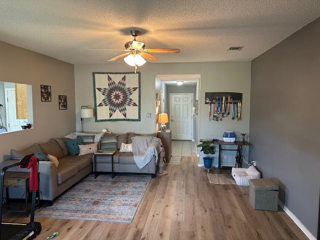 1227 Elmo Ln, San Angelo, TX 76905 - living area with wood finished floors, ceiling fan, and a textured ceiling