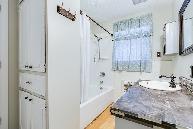 bathroom with wood-type flooring, backsplash, shower / bath combination with curtain, vanity, and a textured ceiling