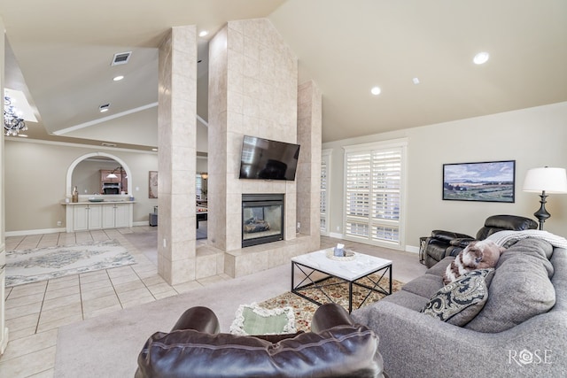 living room featuring light tile patterned flooring, a fireplace, and high vaulted ceiling