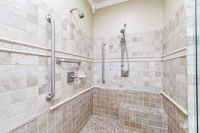 bathroom with ornamental molding and tiled shower