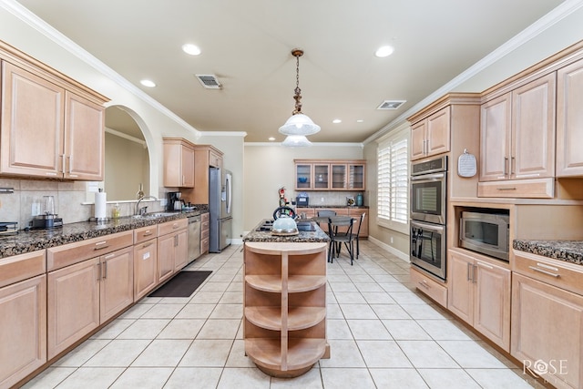 kitchen with pendant lighting, light tile patterned floors, stainless steel appliances, a kitchen island, and light brown cabinets