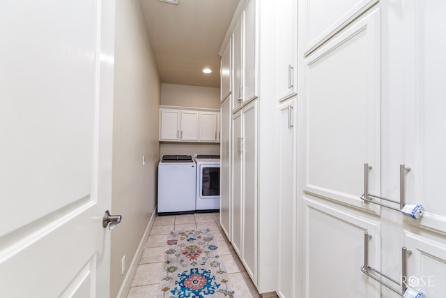 clothes washing area with cabinets, light tile patterned flooring, and washer and dryer