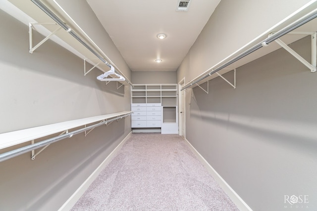 walk in closet featuring light carpet