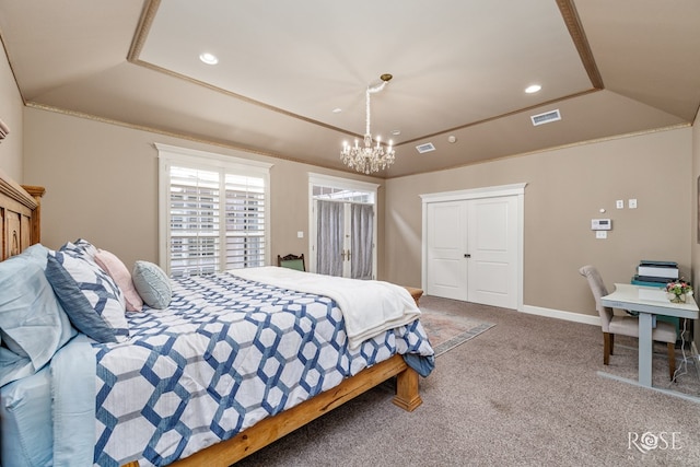 bedroom featuring lofted ceiling, a notable chandelier, a tray ceiling, and carpet flooring