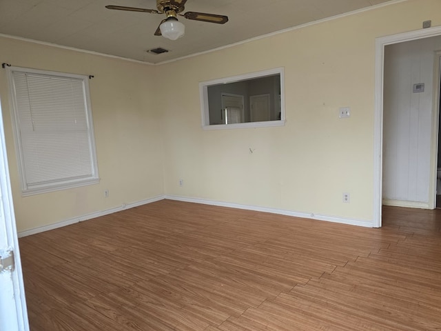 empty room with crown molding, ceiling fan, and light wood-type flooring