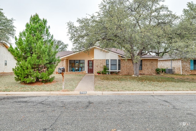 view of front of home with a front lawn and central air condition unit