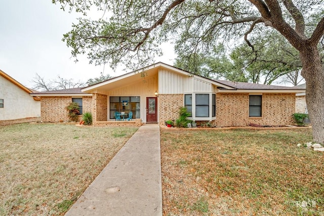 view of front of house featuring a front yard and brick siding