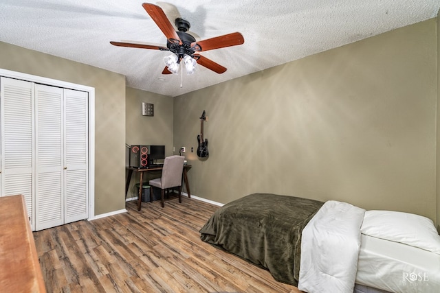 bedroom with hardwood / wood-style flooring, ceiling fan, a textured ceiling, and a closet