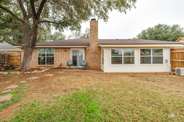 back of house featuring ac unit and a lawn