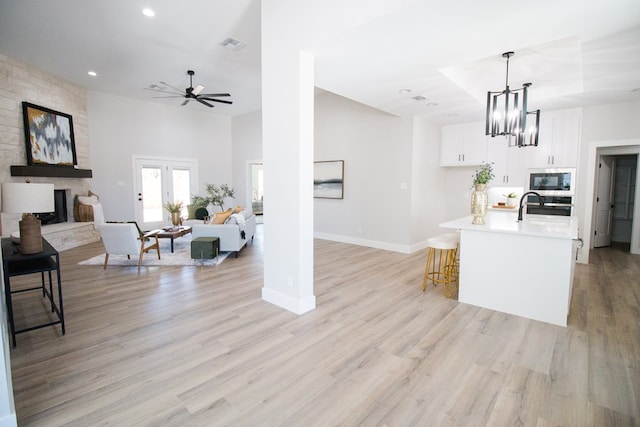 kitchen with open floor plan, a stone fireplace, and built in microwave