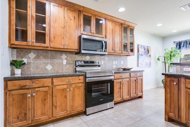 1113 Windemere Cir, San Angelo, TX 76901 - kitchen featuring appliances with stainless steel finishes, brown cabinets, baseboards, tasteful backsplash, and recessed lighting