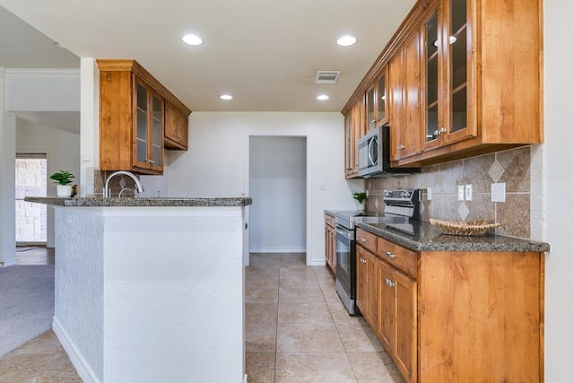 1113 Windemere Cir, San Angelo, TX 76901 - kitchen with electric range oven, glass insert cabinets, dark stone counters, stainless steel microwave, and recessed lighting