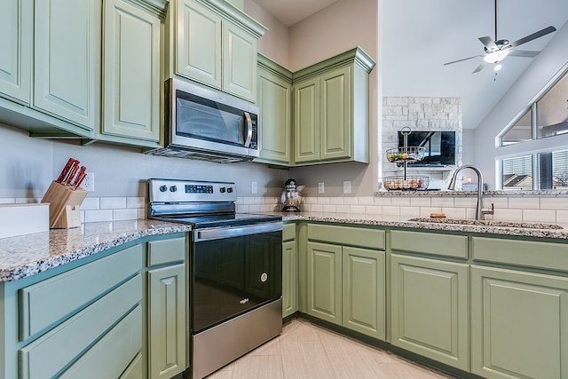 kitchen featuring a sink, stainless steel appliances, green cabinets, and a ceiling fan