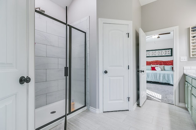 full bath featuring connected bathroom, baseboards, a ceiling fan, and a shower stall