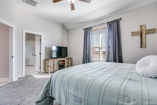 carpeted bedroom featuring visible vents, a ceiling fan, baseboards, connected bathroom, and lofted ceiling