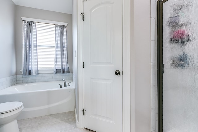 bathroom with a garden tub, toilet, a stall shower, and tile patterned floors