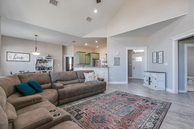 living area featuring visible vents, light wood-type flooring, and baseboards