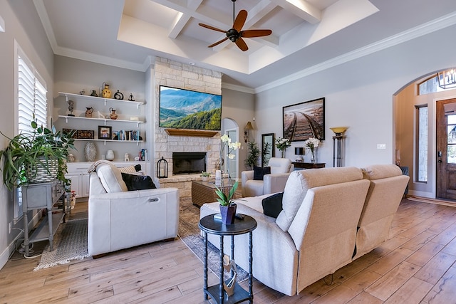 living room featuring beamed ceiling, a fireplace, coffered ceiling, and light hardwood / wood-style flooring