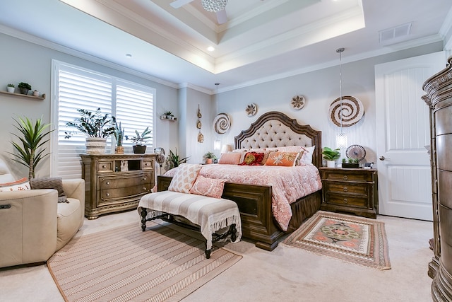 bedroom featuring crown molding, a tray ceiling, and light carpet