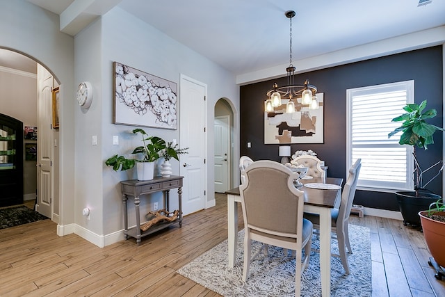 dining space with a notable chandelier and light wood-type flooring