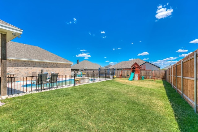 view of yard featuring a fenced in pool and a playground