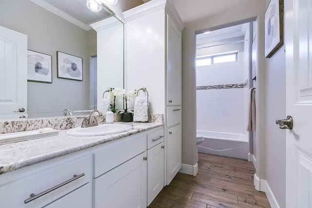 full bathroom featuring hardwood / wood-style flooring, vanity, ornamental molding, shower / washtub combination, and toilet