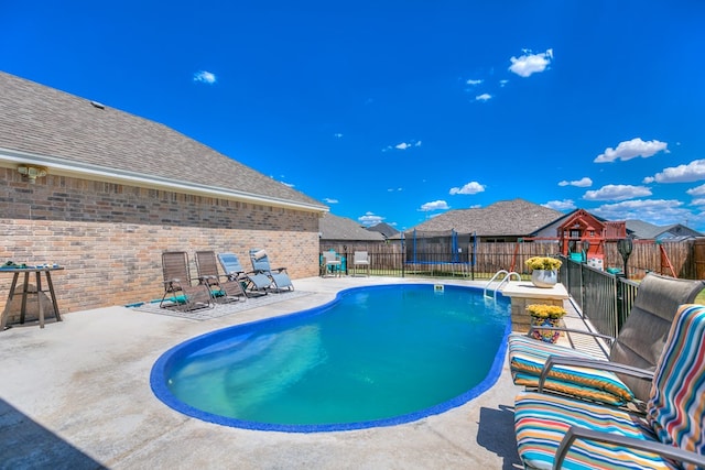 view of pool with a patio and a trampoline