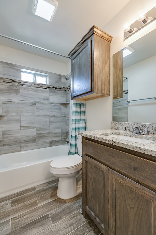 bathroom with wood finish floors, toilet, shower / bath combo, and vanity