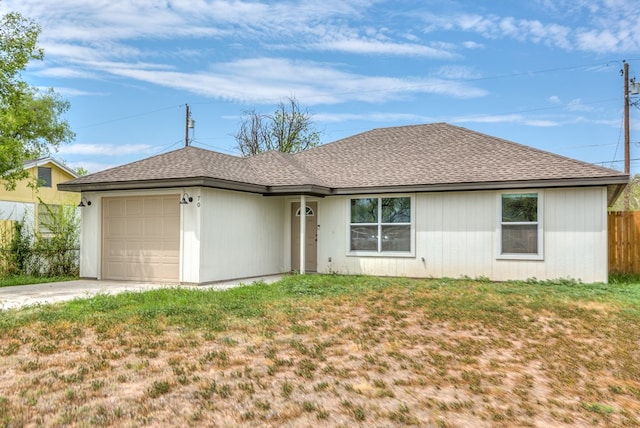 ranch-style home with a front lawn, fence, roof with shingles, a garage, and driveway