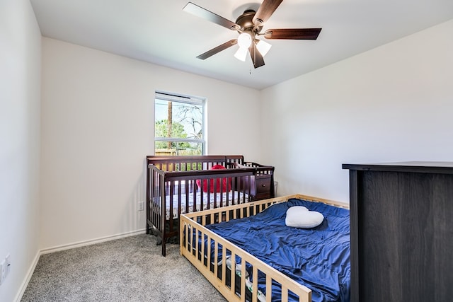 carpeted bedroom featuring baseboards and a ceiling fan