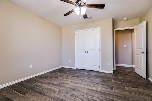 unfurnished bedroom with visible vents, dark wood-type flooring, a closet, baseboards, and ceiling fan