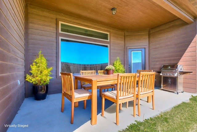 view of patio featuring outdoor dining area, a grill, and fence