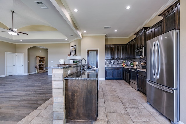 kitchen featuring dark brown cabinetry, visible vents, backsplash, and stainless steel appliances