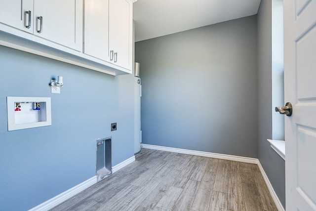 laundry area featuring cabinets, electric dryer hookup, hookup for a washing machine, and light hardwood / wood-style floors