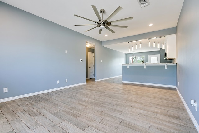 unfurnished living room featuring ceiling fan