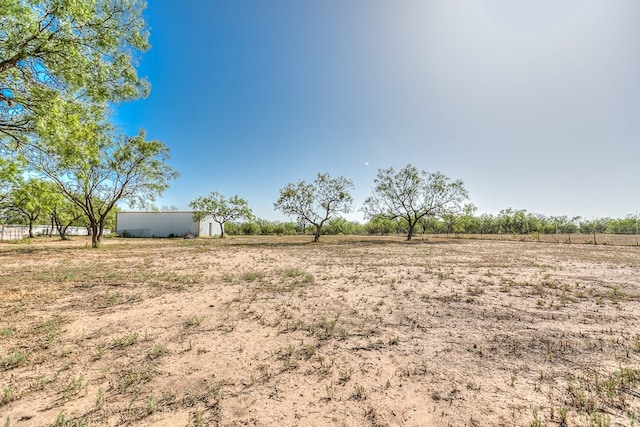 view of yard with an outdoor structure and a rural view