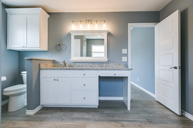 bathroom featuring vanity, toilet, and hardwood / wood-style floors