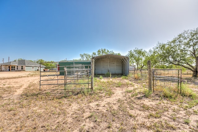 view of outdoor structure featuring a carport and a rural view