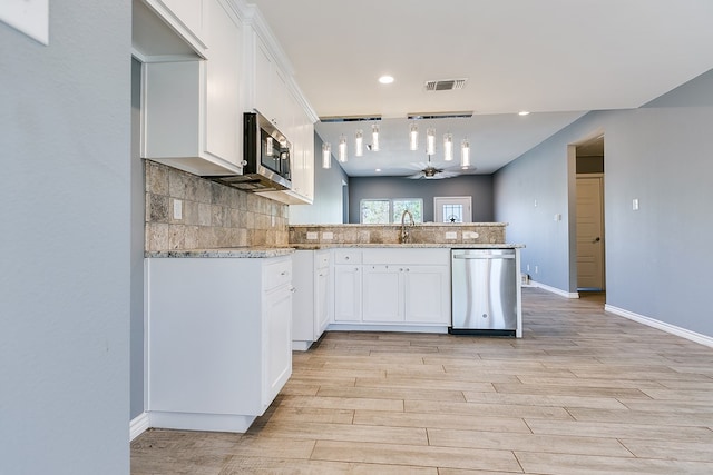 kitchen featuring appliances with stainless steel finishes, sink, decorative backsplash, and white cabinets