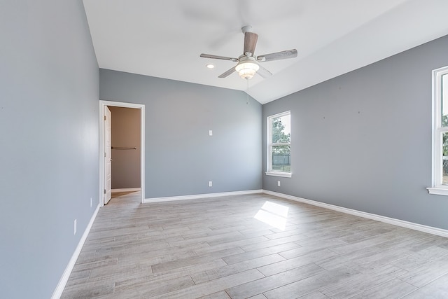 spare room with vaulted ceiling, ceiling fan, and light wood-type flooring